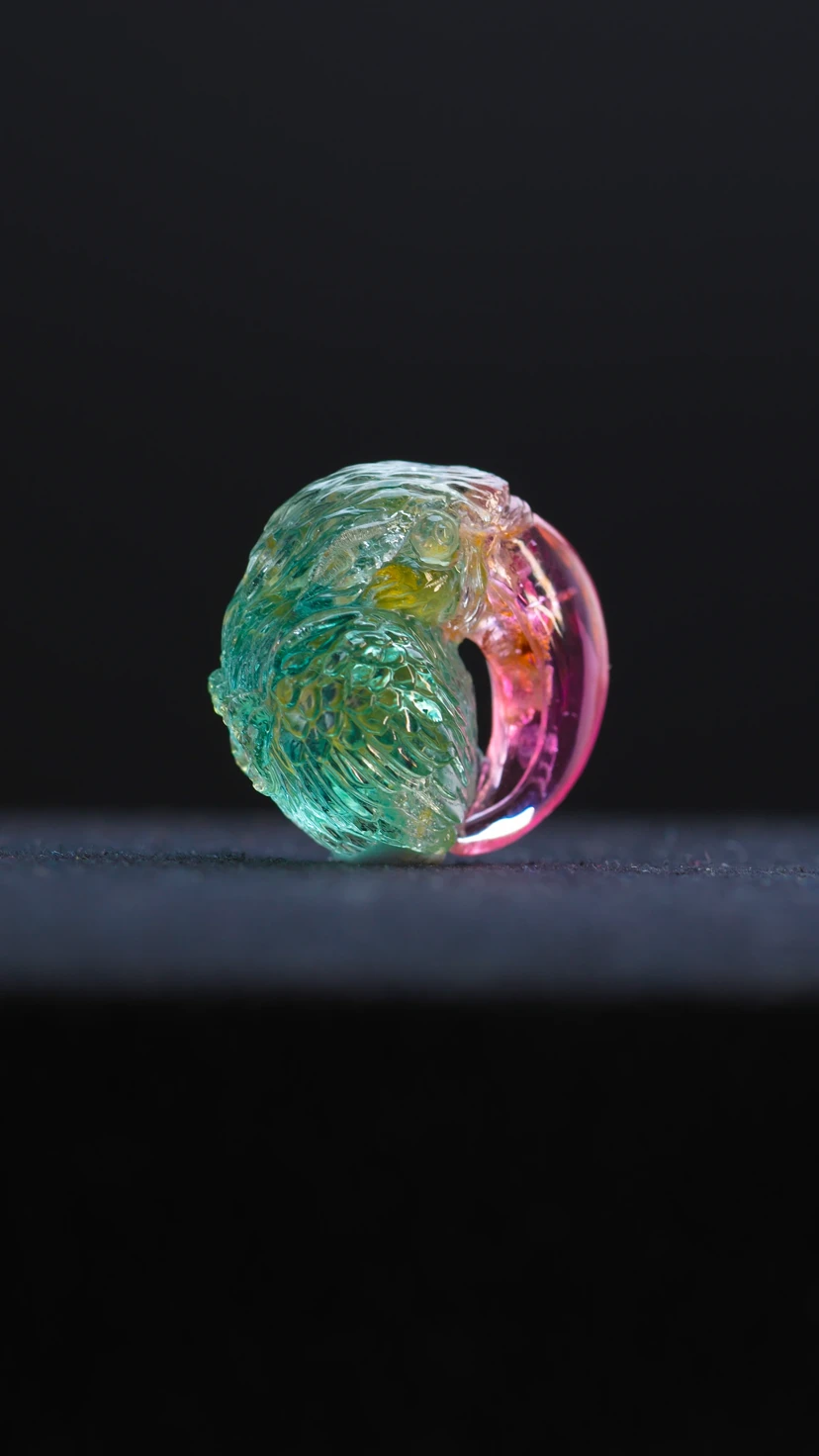 The founder studying a blue rough gemstone in profile