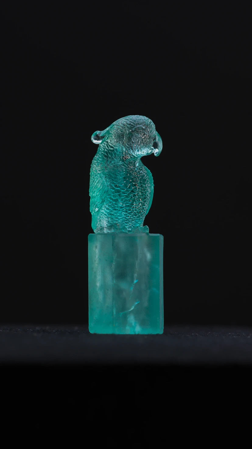 The founder studying a blue rough gemstone in profile